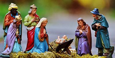 Wir sehen auf kleine sehr bunte tönerne Krippenfiguren. Von links nach rechts sind zu sehen, stehend die heiligen drei Könige, Maria kniend, das Jesuskind in einer Futterkrippe, Josef kniend und stehend ein Hirte. Alle blicken das Kind, das mit einem Heiligenschein dargestellt ist und unzugedeckt in der Krippe liegt und mit ausgebreiteten Armen nach oben schaut, betend an. Die Könige halten Geschenke in den Händen.
