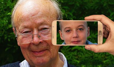 Es sieht aus wie Zauberei. Wir sehen auf den Kamerabildschirm eines Smartphones, das gerade einen lächelnden älteren Herrn fotografiert. Das Bild in der Kamera zeigt ihn als Jugendlichen.