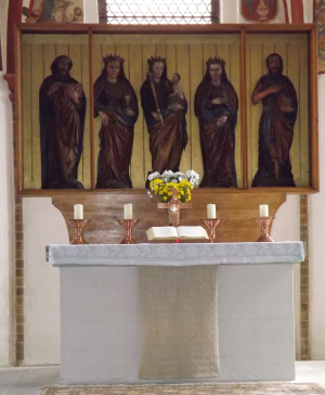 Foto: Altar mit Steinsockel und -tisch sowie einem dreiflügligen Aufbau mit 5 Figuren aus Holz